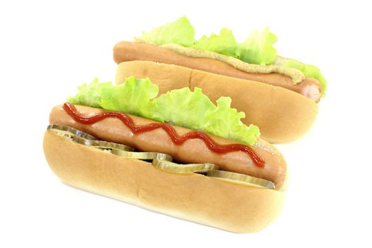 Hot dog with pickle, lettuce leaf, sausage, mustard and ketchup