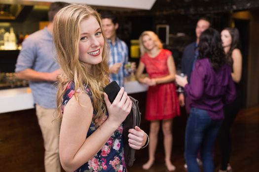 Pretty blonde smiling at camera at the bar