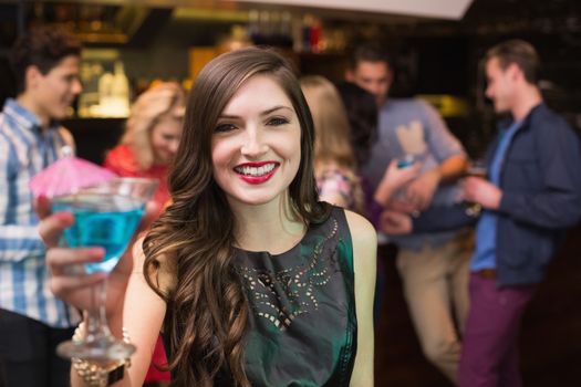 Pretty brunette drinking a cocktail at the bar