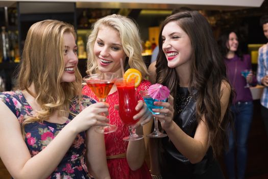 Pretty friends drinking a cocktail at the bar