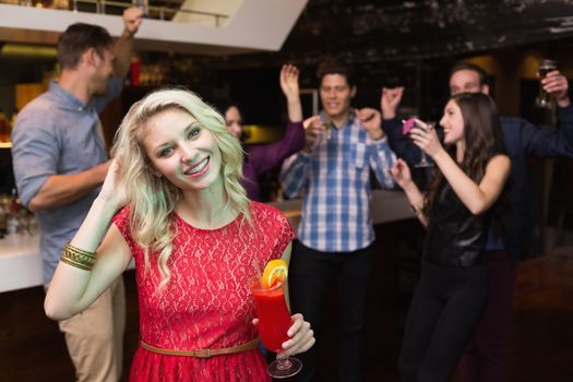 Pretty blonde drinking a cocktail at the bar