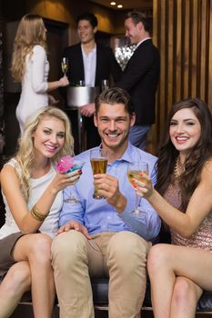 Happy friends having a drink together at the bar