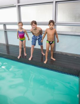 Cute swimming class about to jump in pool at the leisure center