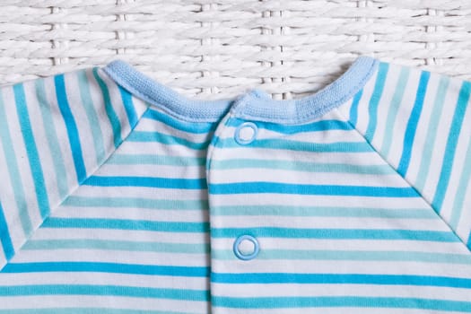 Part of a stripey blue and white cotton baby top