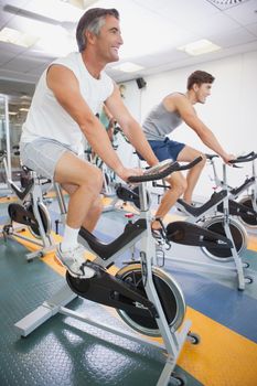 Fit people working out on the exercise bikes at the gym