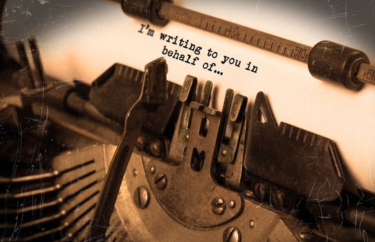 Close-up of an old typewriter with paper, selective focus, I'm writing to you in behalf of