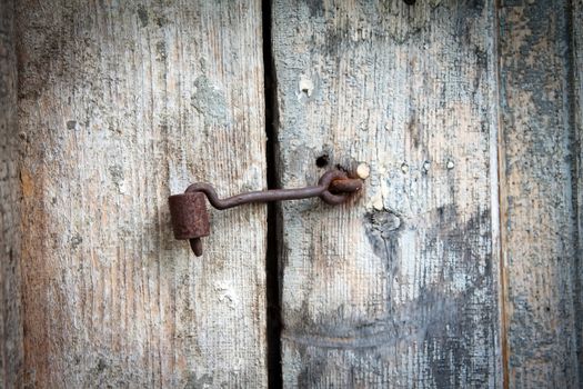 old rusty metal hook on the old door