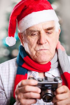 Senior man taking photo against Christmas background