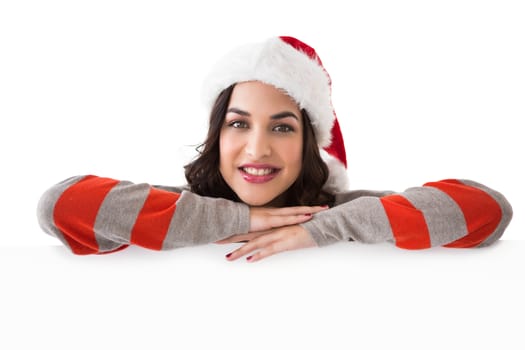 Beauty brunette in santa hat smiling at camera on white background