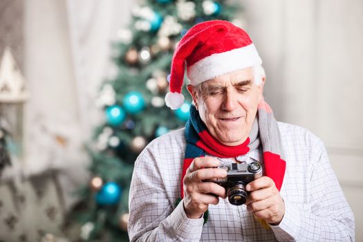 Senior man taking photo against Christmas background