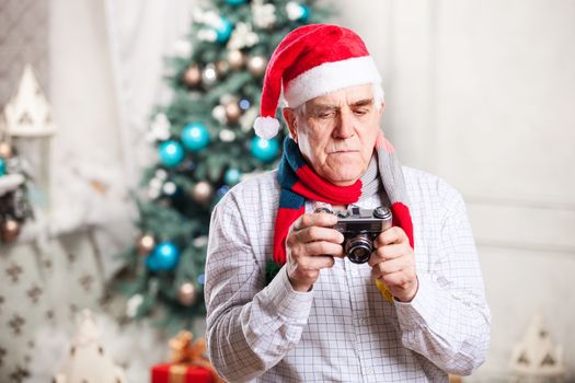 Senior man taking photo against Christmas background