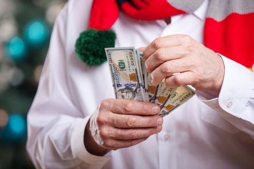Senior man with money over Christmas background