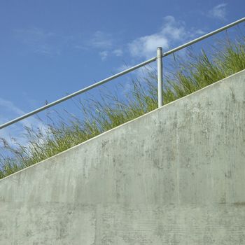 Industrial hand rail with grass and blue sky