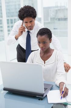 Team on the phone and taking notes in the office