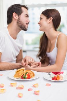 Young couple having a romantic breakfast at home in the kitchen