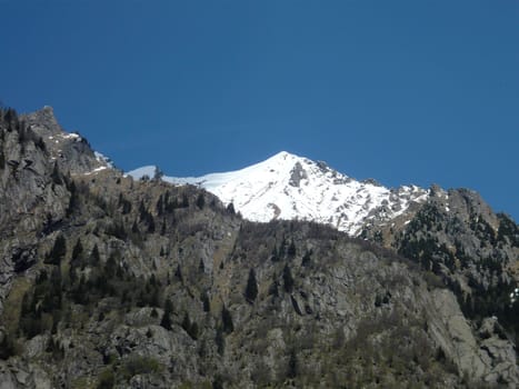 Mountain snowy peak of the Alps on Spring. Land for hiking, mountain running, mountaineering and other outdoor activities. Val Masino, Lombardy, Italy