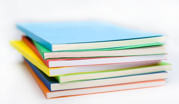 Horizontal shot of isolated on the white background stack of vivid ledgers