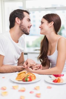 Young couple having a romantic breakfast at home in the kitchen