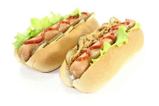 Hot dogs with cucumber, salad, sausage, fried onions and ketchup