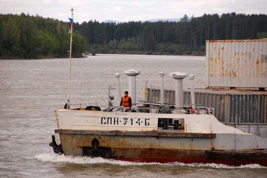 Cargo ship with sailor at Kolyma river, Russia