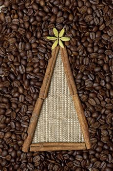 Christmas tree made of cinnamon sticks on coffee and sack background