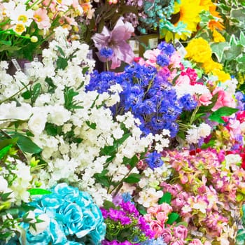 Colorful synthetic flowers as a background
