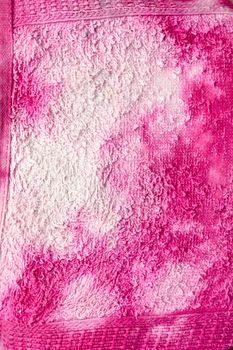 White bleach stains on a pink towel