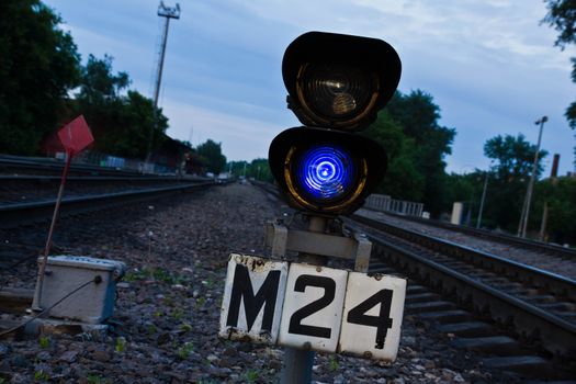 Railway traffic light on the background of trees