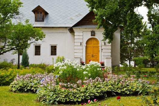 house of white stone and the flower beds