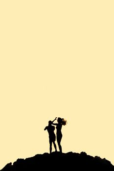 Man and woman standing on mountain silhouette with copy space