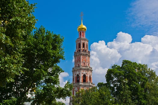 old red brick bell tower among the trees