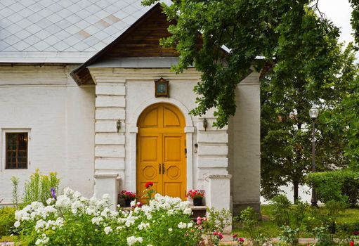 house of white stone among the flower beds