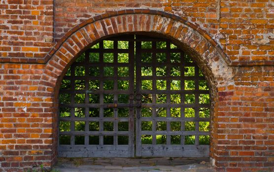 old wooden gate and red brick wall