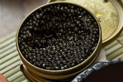 Black caviar in small round metal tin on ice