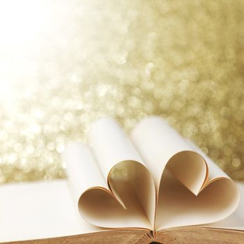 Heart shaped book pages on glitter background