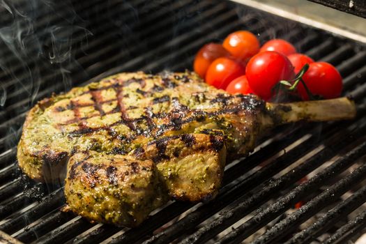 steak flame broiled on a barbecue with vegetables. shallow depth of field. 