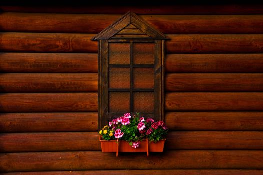 wall of the wooden house with a window and flowers