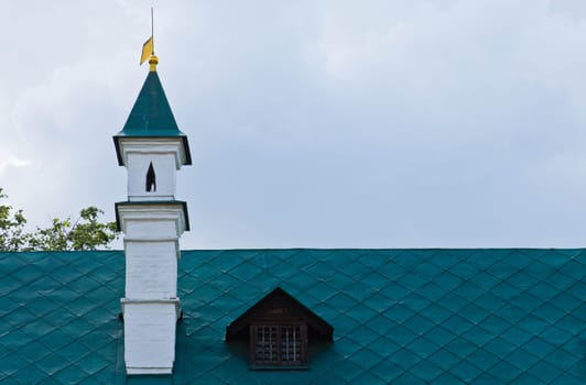 iron roof of the old manor with a brick chimney