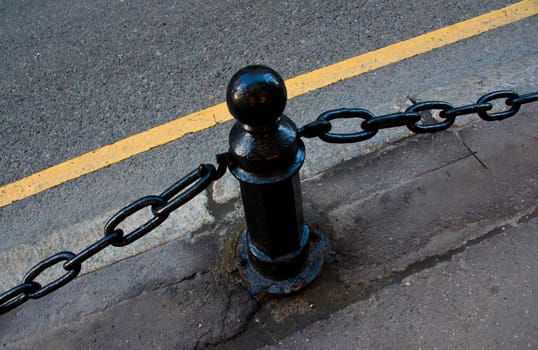 iron fence with a chain in the roadway