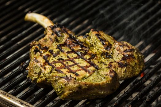 steak flame broiled on a barbecue with vegetables. shallow depth of field. 