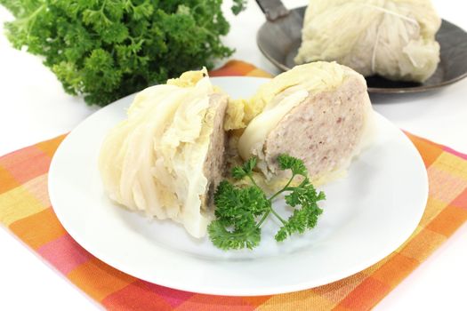 Savoy cabbage roulade with parsley against white background