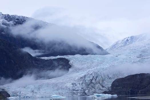 Misty hues of blue of the receding tongue of the Mendenhall Glacier and its ice melt lake in Juneau, Alaska