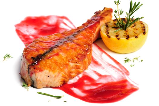 Grilled salmon steak with red sauce, lemon and rosemary, on white