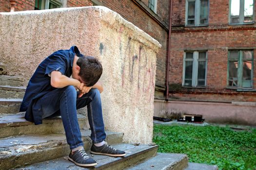 Sad Teenager on the landing steps of the Old House