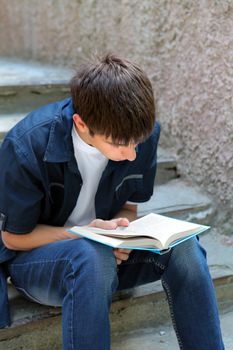 Teenager read the Book on the landing steps