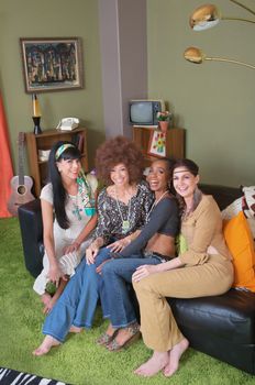 Group of four hippies sitting on leather sofa