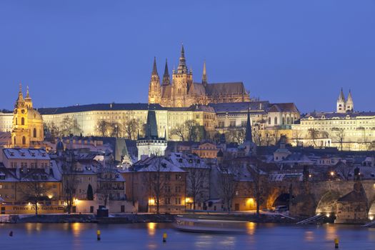 prague in winter - charles bridge and hradcany castle at dusk