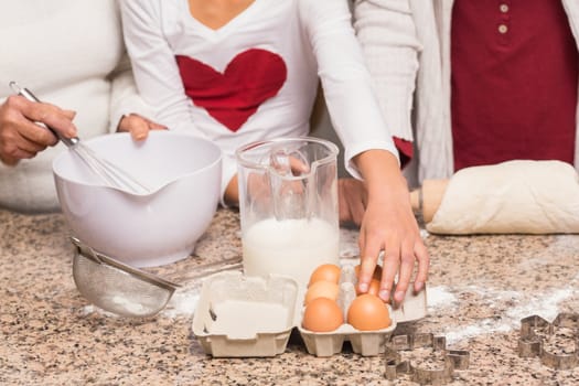 Multi-generation family baking together at home in the kitchen