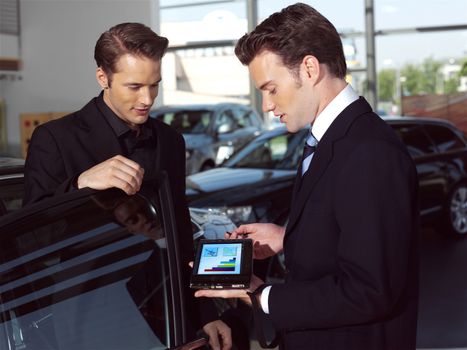 Car salesperson explaining car features to customer