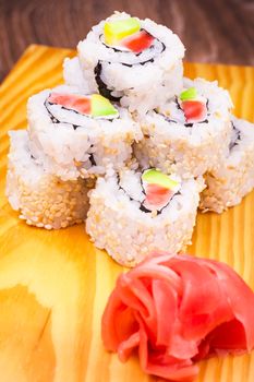 inside out sushi roll with salmon and avocado on wooden background 